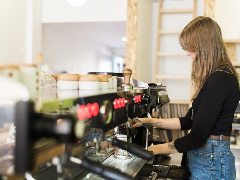 A Young Female Barista Making Coffee